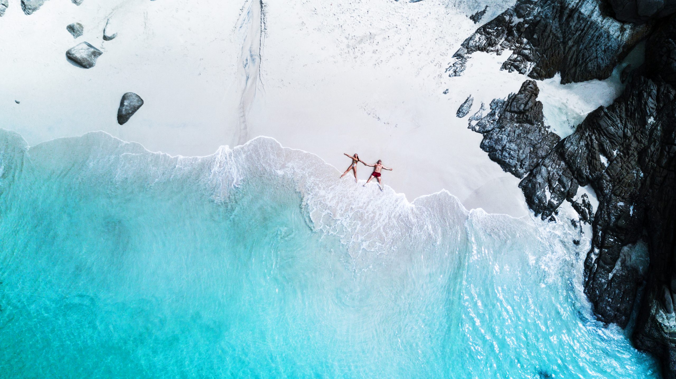 beach-drone-view-tropical-island-white-beach-with-waves-couple-lay-down-beach